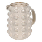 White ceramic pitcher with textured surface on a white background