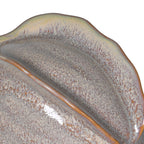 Close-up of a ceramic dish with textured surface and brown rim on a white background