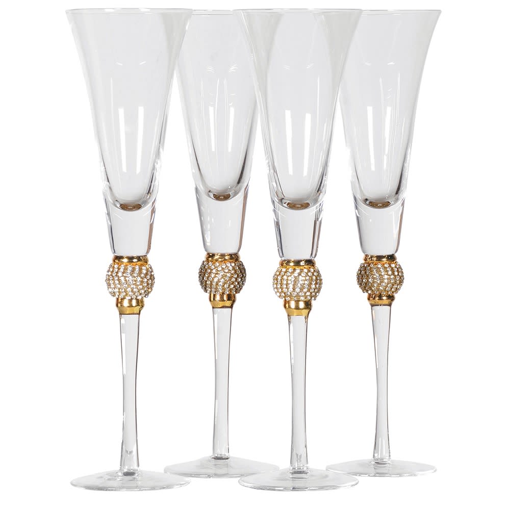 Set of four clear champagne flutes with gold decorative bases on a white background