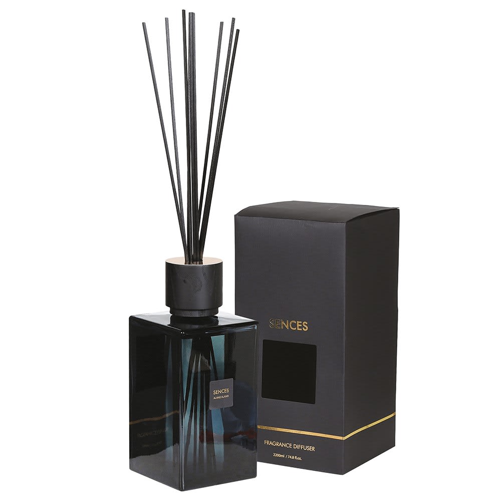 Black fragrance diffuser with reeds and packaging on a white background