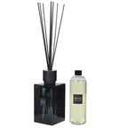 Black diffuser with reeds and a bottle of Sences fragrance on a white background