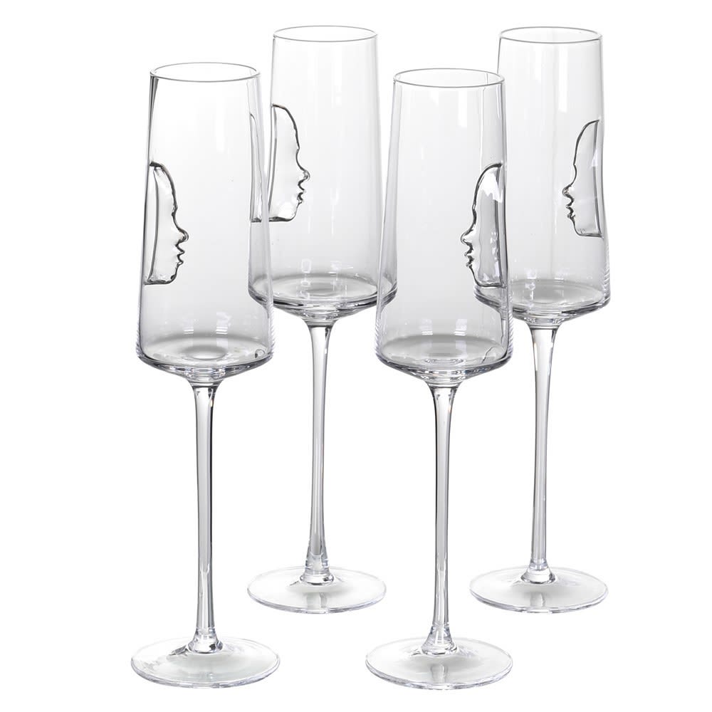 Set of four clear champagne flutes with face outlines on a white background