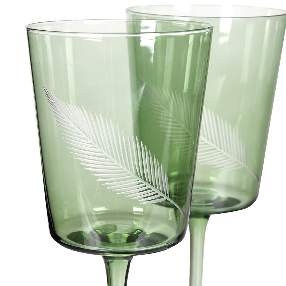 Two green glasses with leaf patterns on a white background