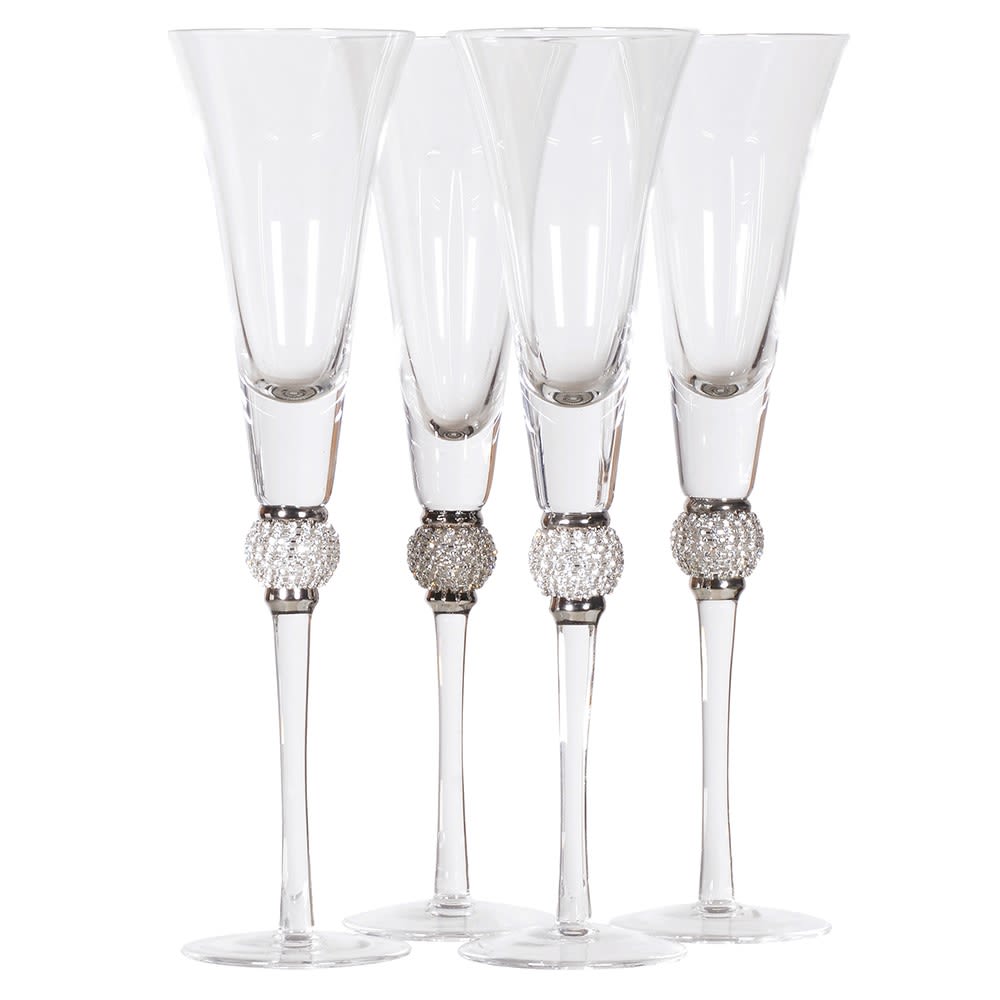 Set of four clear champagne flutes with decorative silver bases on a white background