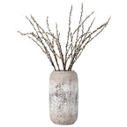Decorative vase with textured surface holding dried branches on a white background
